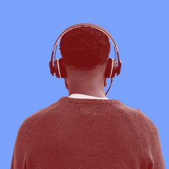 Rear view of man listening to headphones at beach, Coney Island, New York, USA