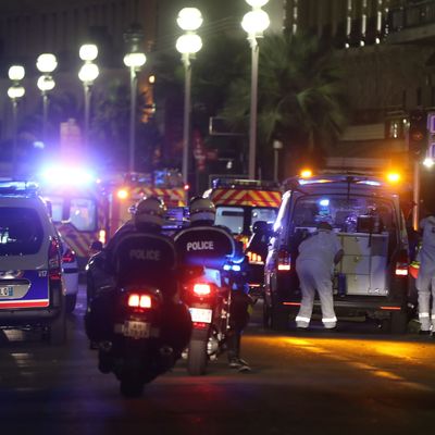 Police officers and rescue workers arrive at the scene of an attack on July 14, 2016, after a van plowed into a crowd leaving a fireworks display in the French Riviera town of Nice.