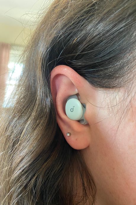An earbud in a person's ear.