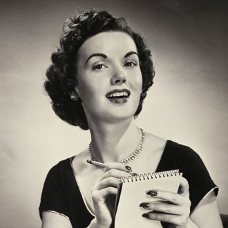 Portrait of a young woman writing on a notepad