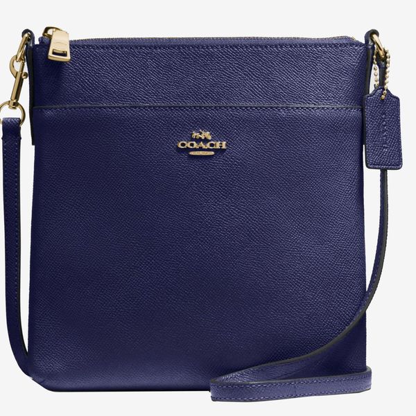 The Coach Kitt crossbody messenger bag in navy blue with gold accents and a small gold coach logo. The Strategist - 48 Things on Sale You’ll Actually Want to Buy: From Sunday Riley to Patagonia