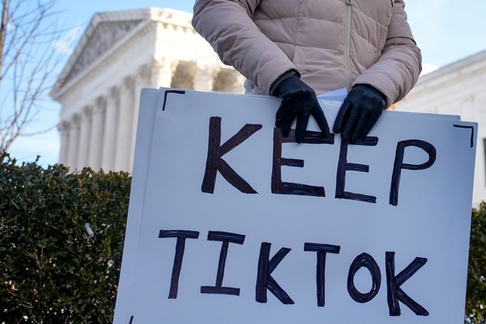 A content creator on TikTok, holds a sign outside the U.S. Supreme Court Building