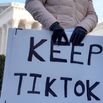 A content creator on TikTok, holds a sign outside the U.S. Supreme Court Building