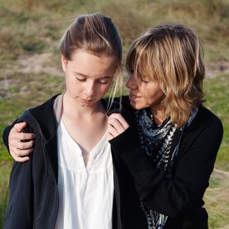 A Mother Comforts Her Daughter As They Walk Together