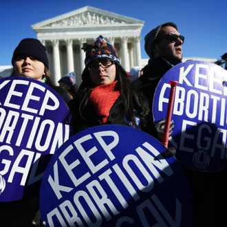 Pro-choice activists hold signs as marchers of the annual March for Life arrive in front of the U.S. Supreme Court January 22, 2014 on Capitol Hill in Washington, DC. Pro-life activists from all around the country gathered in Washington for the event to protest the Roe v. Wade Supreme Court decision in 1973 that helped to legalize abortion in the United States. 