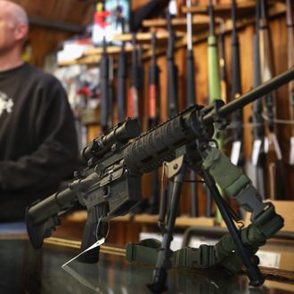 TINLEY PARK, IL - DECEMBER 17: An AR-15 style rifle sits on the counter by Craig Marshall as he assists a customer at Freddie Bear Sports sporting goods store on December 17, 2012 in Tinley Park, Illinois. Americans purchased a record number of guns in 2012 and gun makers have reported a record high in demand. Firearm sales have surged recently as speculation of stricter gun laws and a re-instatement of the assault weapons ban following the mass school shooting in Connecticut . (Photo by Scott Olson/Getty Images)