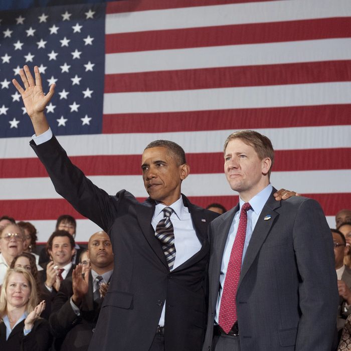 US President Barack Obama waves alongside Richard Cordray (R) on January 4, 2012.