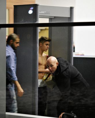 Image #: 21764087 Bodyguards try to block the view of Canadian singer Justin Bieber as he goes through Wladyslaw Reymont Airport in Lodz following his concert March 25, 2013. REUTERS/Tomasz Stanczak/Agencja Gazeta (POLAND - Tags: ENTERTAINMENT PROFILE) REUTERS /AGENCJA GAZETA /LANDOV