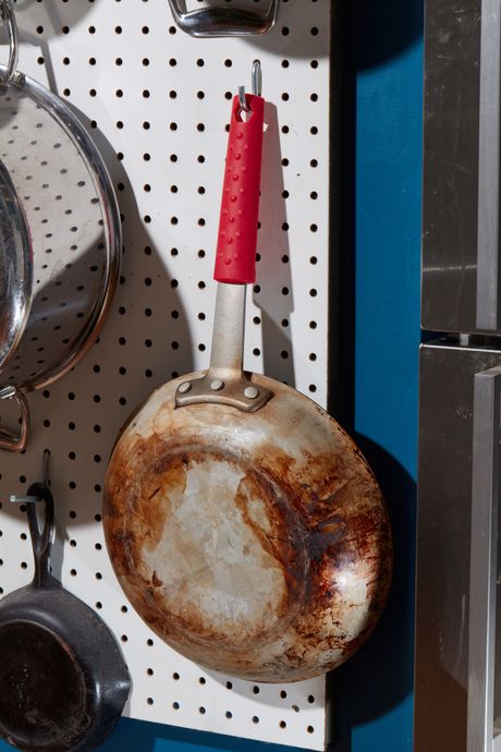 A pegboard with a pan hanging from it