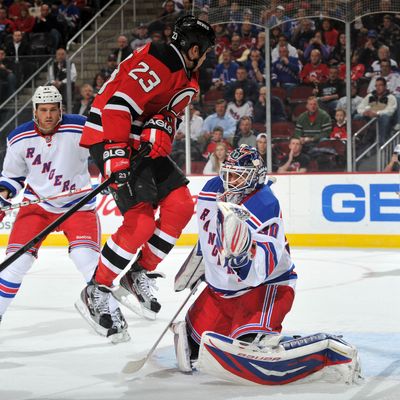 David Clarkson #23 of the New Jersey Devils leaps in front of Henrik Lundqvist #30 of the New York Rangers