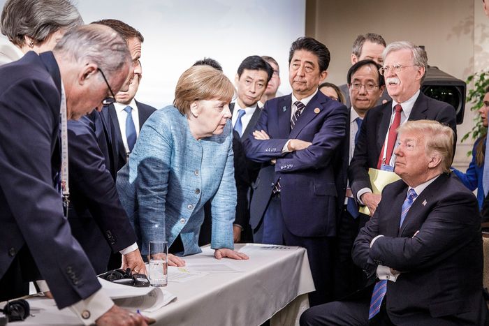 German Chancellor Angela Merkel and other world leaders stare at President Donald Trump, who is seated with his arms crossed, at the G7 Summit on June 8, 2018.