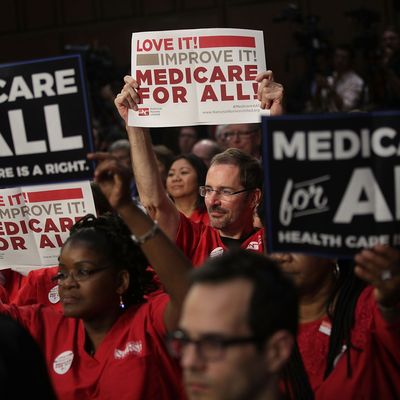 Supporters of U.S. Sen. Bernie Sanders hold signs during an event to introduce the Medicare for All Act of 2017.
