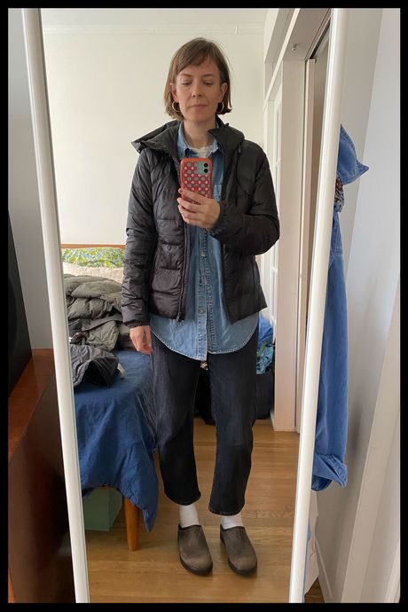 Photo of Strategist senior writer Liza Corsillo wearing the Quince Women's Lightweight Down Hooded Packable Puffer in black.
