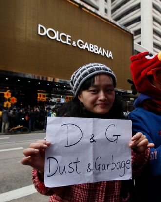 Protesters hold a placard outside a chain store of Dolce & Gabbana in Hong Kong Sunday, Jan. 8, 2012. Hundreds of Hong Kong protesters staged a protest outside an Italian luxury clothing chain store Dolce & Gabbana to demand an apology from the chain for allegedly preventing locals from taking photos of its storefront display. One of the security guards had earlier been reported as saying that only Mainland shoppers were allowed to take pictures of the store, even at the public road outside. 