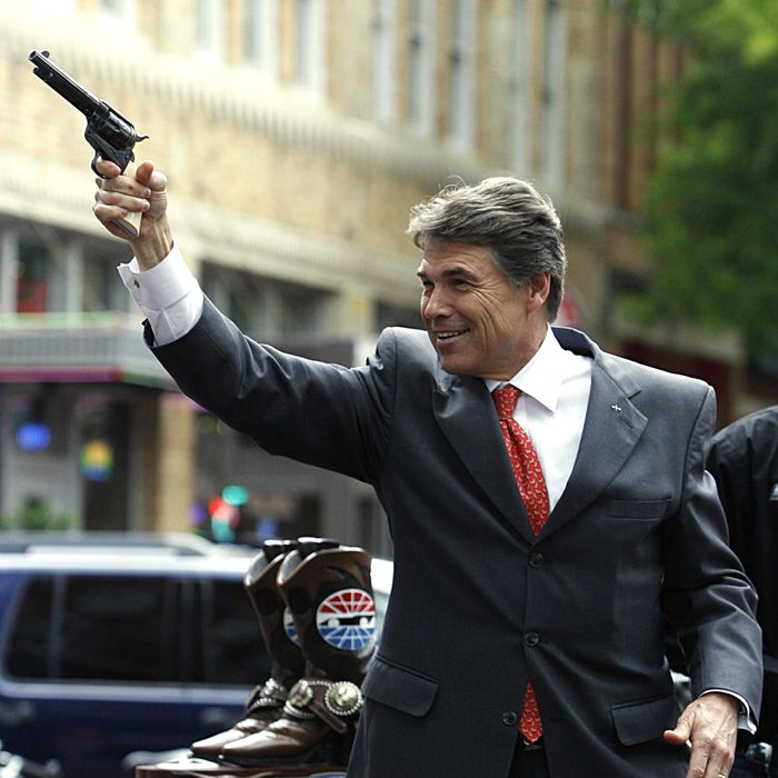 FORT WORTH, TX - APRIL 15: Texas Governor Rick Perry fires a six-shooter revolver in downtown Fort Worth during a promotional event with Texas Motor Speedway on April 15, 2010 in Fort Worth, Texas. (Photo by Tom Pennington/Getty Images)