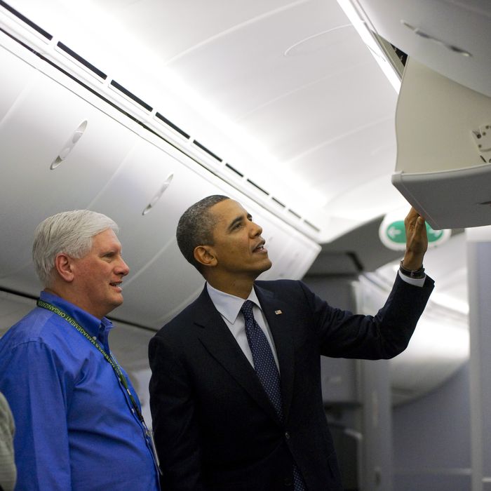 US President Barack Obama looks at the overhead bin in a Boeing 787 Dreamliner that will be delivered to United Airlines during a tour of the production facility prior to speaking on the economy in Everett, Washington, on February 17, 2012.