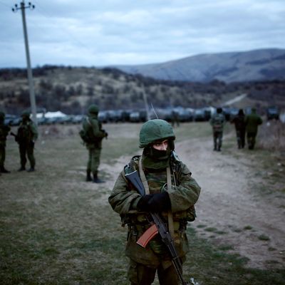 Members of the Russian armed forces stand guard around the Ukrainian military base in the village of Perevalne, 20 km south of Simferopol, on March 2, 2014. Russias armed forces have surrounded Ukraine's troops in the Perevalnoye neighborhood in Ukraine's Autonomous Republic of Crimea, on Sunday. Ukraines military units in Perevalnoye, some 20 km far from Crimeas capital Simferopol, were encircled by more than 200 Russian soldiers. Russia currently has 25 armored vehicles in the region. 