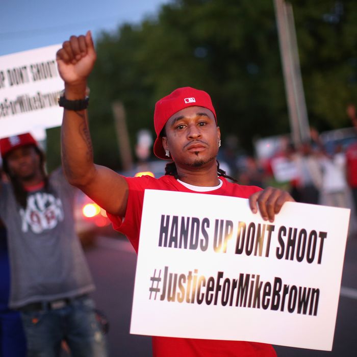 ST. LOUIS, MO - AUGUST 12: Demonstrators protest the killing of teenager Michael Brown outside Greater St. Marks Family Church while Brown’s family along with civil rights leader Rev. Al Sharpton and a capacity crowd of guests met inside to discuss the killing on August 12, 2014 in St Louis, Missouri. Brown was shot and killed by a police officer on Saturday in the nearby suburb of Ferguson. Ferguson has experienced two days of violent protests since the killing but, tonight the town remained mostly peaceful. (Photo by Scott Olson/Getty Images)