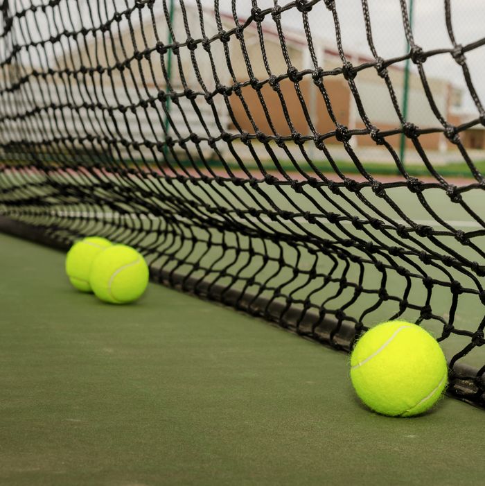 Three tennis balls near net