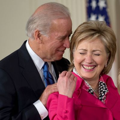 U.S. Vice President Joseh Biden, left, and Secretary of State Hillary Clinton share a laugh during a signing ceremony for the Lilly Ledbetter Fair Pay Restoration Act in the East Room of the White House in Washington, D.C., U.S., on Thursday, Jan. 29, 2009. U.S. President Barack Obama, signing the first legislation of his presidency, made it easier for U.S. workers to win pay-discrimination lawsuits. Photographer: Mannie Garcia/Bloomberg News