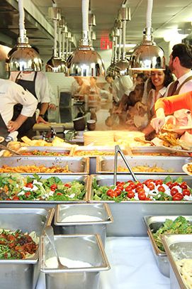 家庭聚餐在山口占据了大约10英尺的空间。厨师们从热的一面靠近，前面的工作人员排成一排，延伸到热的队伍的整个长度，还有几十人在厨房外的走廊上等待。每户人家的一顿饭可以养活一百多人。