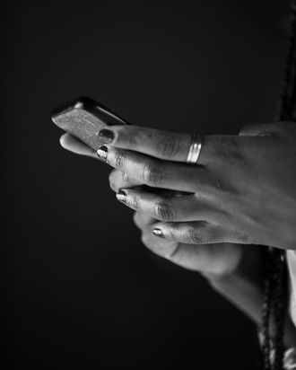 Close up shot of unrecognizable woman typing a text message on a small phone