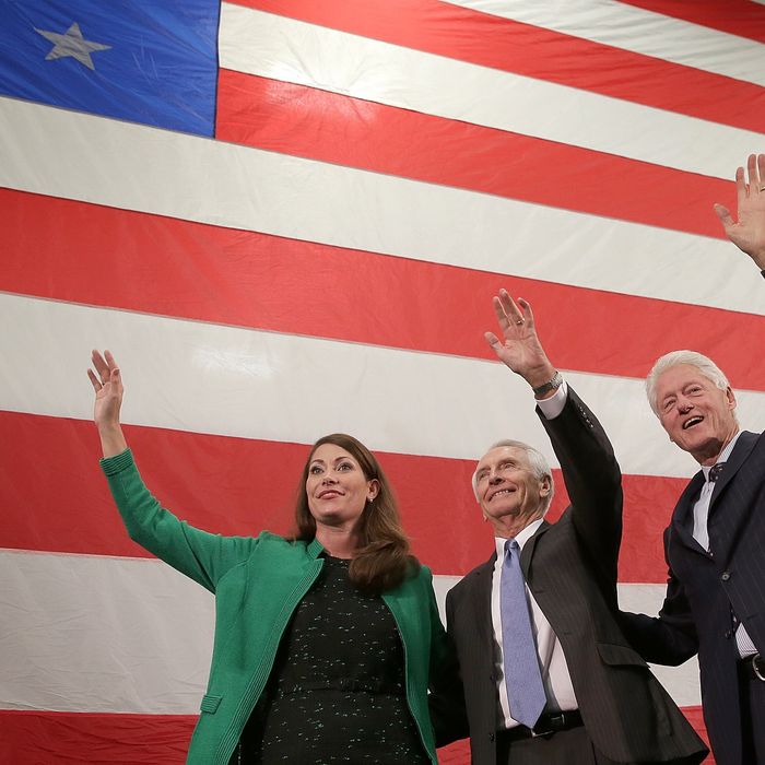 Former U.S. President Bill Clinton (R) campaigns for U.S. Senate Democratic candidate and Kentucky Secretary of State Alison Lundergan Grimes (L) with Kentucky Gov. Steve Beshear (C) during a rally October 21, 2014 in Paducah, Kentucky. Grimes remains locked in a tight race with Senate Minority Leader Mitch McConnell (R-KY) with midterm elections less than two weeks away. 
