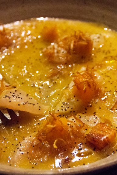 The red-snapper tiradito is immersed in yuzu-persimmon leche de tigre and garnished with poppy seeds and candied ginger.
