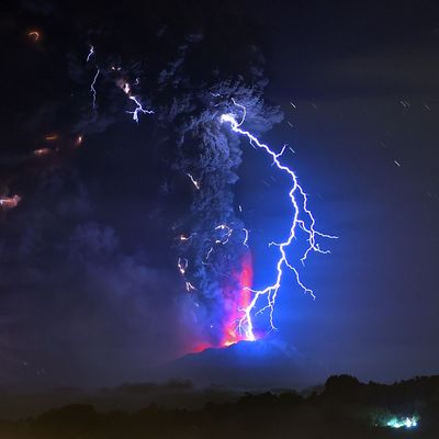 View from Frutillar, southern Chile, showing volcanic lightnings and lava spewed from the Calbuco volcano on April 23, 2015. Chile's Calbuco volcano erupted on Wednesday, spewing a giant funnel of ash high into the sky near the southern port city of Puerto Montt and triggering a red alert. Authorities ordered an evacuation for a 10-kilometer (six-mile) radius around the volcano, which is the second in southern Chile to have a substantial eruption since March 3, when the Villarrica volcano emitted a brief but fiery burst of ash and lava. AFP PHOTO/MARTIN BERNETTI (Photo credit should read MARTIN BERNETTI/AFP/Getty Images)