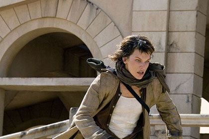 Okay, terrific progress. Maybe TOO much progress. From the lopsided, dirty-looking male-stripper ensemble from RE2, Milla advanced to a trench coat, an unbuttoned henley, a bodysuit, and, in lieu of pants, canvas thigh-highs strapped with artillery. Oh, and fingerless gloves and badass boots. First it seems dowdy, but then you see the peekaboo thighs. No need for the scarf, however.