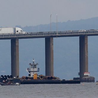 Rescue workers on boats search near a construction barge on the Hudson River in Piermont, N.Y. on Saturday, July 27, 2013, south of the Tappan Zee Bridge for two people who are believed to have fallen into the water during a boat crash. Two people are missing and four others are injured after their boat struck the barge, center, according to the Coast Guard. (AP Photo/Julio Cortez)