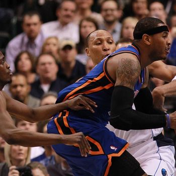 Carmelo Anthony #7 of the New York Knicks dribbles the ball against Shawn Marion #0 and Rodrigue Beaubois #3 of the Dallas Mavericks