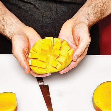 5.把芒果皮从下面往上推，做成芒果块的花朵。