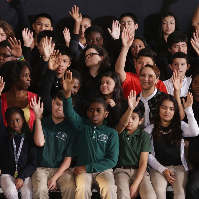 Students raise their hands when asked if they plan on going to college before the arrival of U.S. President Barack Obama at Buck Lodge Middle School February 4, 2014 in Adelphi, Maryland. 