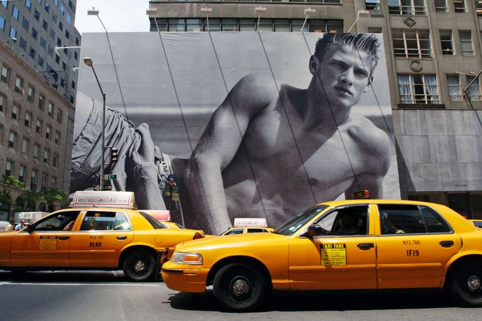Cabs drive in front of a billboard surrounding the future ho