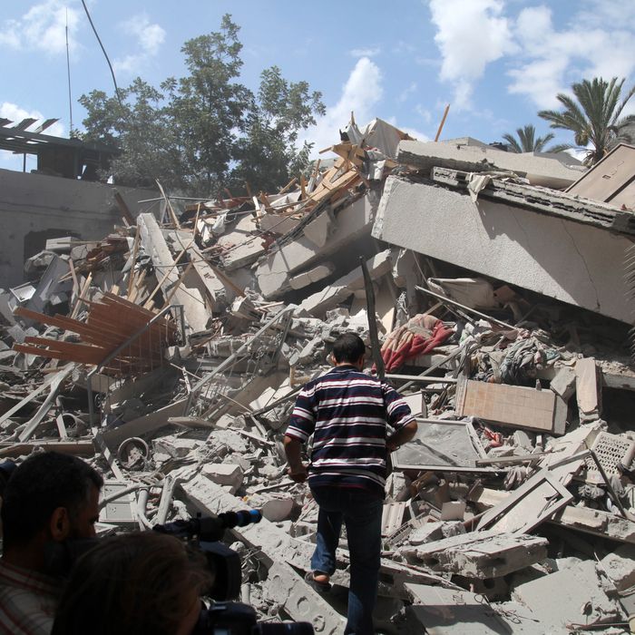 Palestinians look around a house which police said was targeted in Israeli air strikes in Gaza City. 