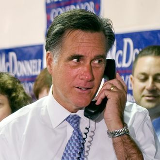 Republican presidential candidate former Governor Mitt Romney (C), R-MA makes a phone call as he greets and thanks Fairfax County Republican Committee phone bank volunteers at their headquarters in Fairfax, Virginia, October 26, 2011. AFP PHOTO/Jim WATSON (Photo credit should read JIM WATSON/AFP/Getty Images)