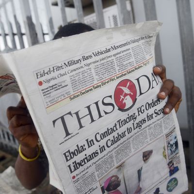A man reads a newspaper with a headline announcing government efforts to screen for Ebola at a newsstand in Lagos on July 27, 2014. Nigeria was on alert against the possible spread of Ebola on July 27, a day after the first confirmed death from the virus in Lagos, Africa's biggest city and the country's financial capital. The health ministry said on July 25 that a 40-year-old Liberian man died at a private hospital in Lagos from the disease, which has now killed more than 650 people in four west African countries since January. AFP PHOTO/PIUS UTOMI EKPEI (Photo credit should read PIUS UTOMI EKPEI/AFP/Getty Images)