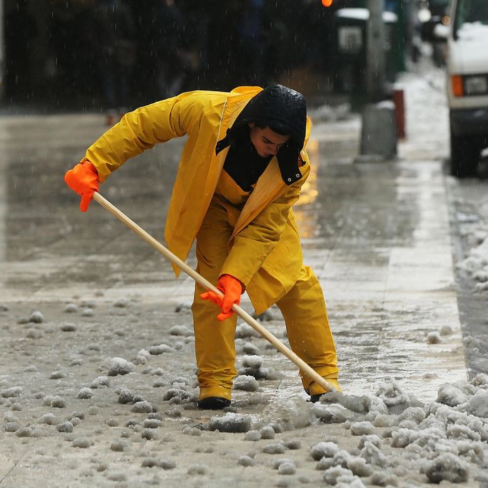 A man clears snow and ice from a sidewalk along Manhattan's streets on February 2, 2015 in New York City. Another winter storm has brought inclement weather to much of the Northeast, canceling schools and hundreds of flights throughout the New York metro area. 