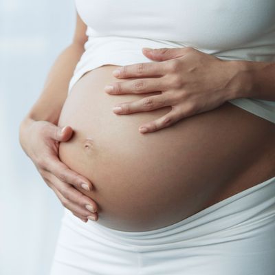 Pregnant woman cradles her protrusion.