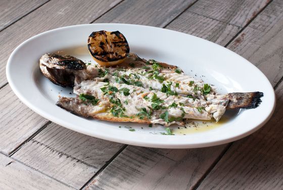 Grilled whole fish lavraki with lemon, extra-virgin olive oil, sea salt, cracked pepper, and herbs.