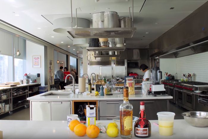 Former Bon Appétit star Sohla El-Waylly standing at a distance in the magazine's Test Kitchen, filled with rows of immaculate white cooking stations and lined with shiny Wolf stoves 