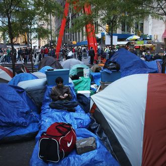 NEW YORK, NY - NOVEMBER 04: A man associated with the 'Occupy Wall Street' movement relaxes in Zuccotti Park in the Financial District near Wall Street on November 4, 2011 in New York City. Despite a freak snowstorm last Saturday and the confiscation of their generators by the fire department, hundreds of young and old are staying put in the park. The activists have been gradually converging on the financial district over the past seven weeks to rally against the influence of corporate money in politics among a host of other issues. The protests have begun to attract the attention of major unions and religious groups as the movement continues to grow in influence around the world. (Photo by Spencer Platt/Getty Images)