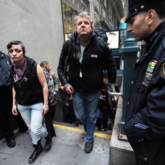 Flanked by New York Police Department officers, demonstrators with 'Occupy Wall Street' exit the subway on their way towards the New York Stock Exchange as they mark the two month anniversary of the protest November 17, 2011 in New York. AFP PHOTO/Stan HONDA (Photo credit should read STAN HONDA/AFP/Getty Images)