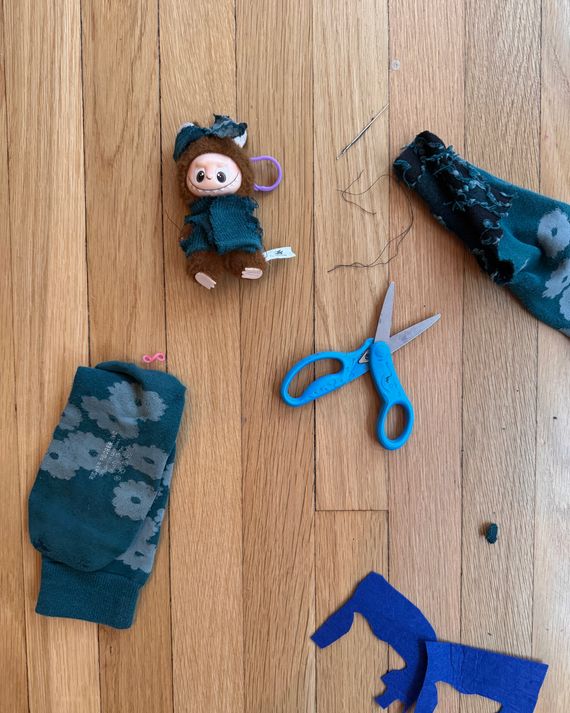 A Labubu doll wearing hand-sewn clothing.