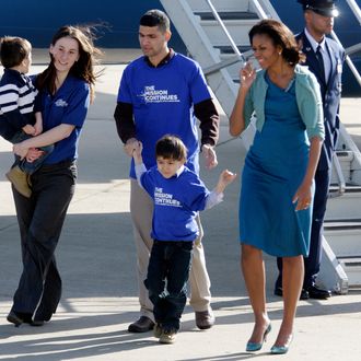 First lady Michelle Obama walks with Cpl. Tiffany Garcia and her husband Omar Garcia and their children Joel, 4, left, and Omar, 5, from The Mission Continues during her arrival at Lambert St. Louis International Airport, Monday, March 5, 2012, in St. Louis. The Mission Continues is a national nonprofit organization challenging post-9/11 veterans to serve and lead in their communities.
