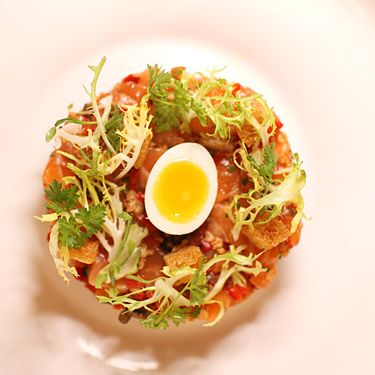 Hand-cut salmon tartare, fried capers, roasted peppers, soft-boiled quail egg.