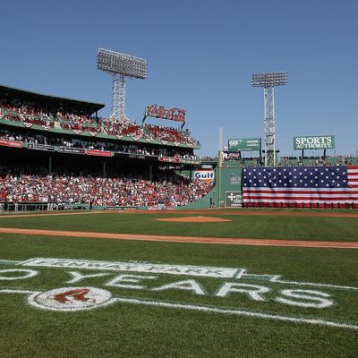 The flag covers the Green Monster as the national anthem is played before the game between the Boston Red Sox and the Tampa Bay Rays on April 16, 2012 at Fenway Park in Boston, Massachusetts.