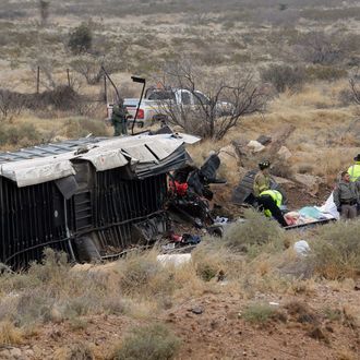 Officials investigate the scene of a prison transport bus crash in Penwell, Texas, Wednesday, Jan. 14, 2015. Law enforcement officials said the bus carrying prisoners and corrections officers fell from an overpass in West Texas and crashed onto train tracks below, killing at least 10 people. (AP Photo/The Odessa American, Mark Sterkel)