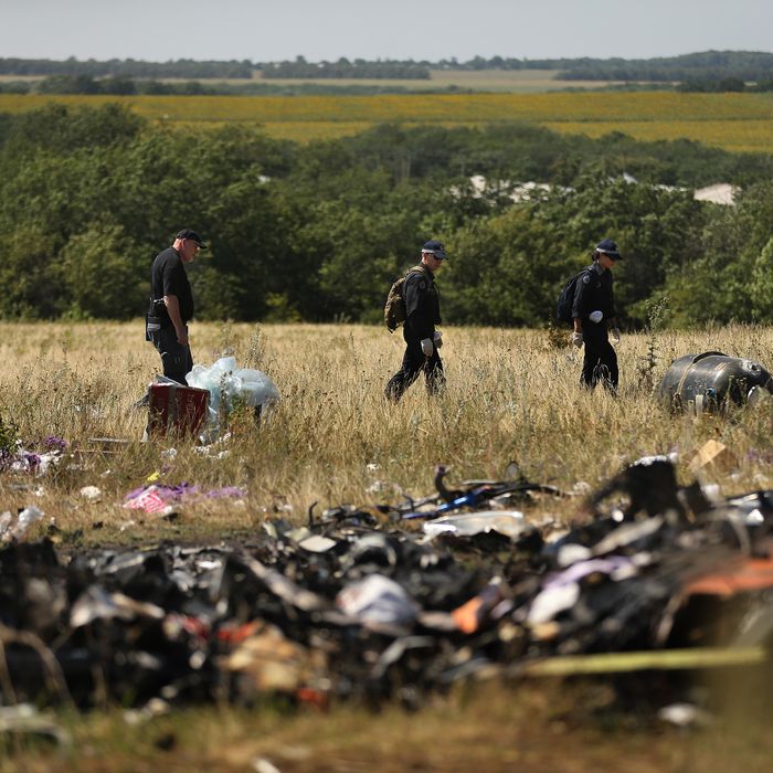 Australian Federal Police officers and their Dutch counterparts collect human remains and personal belongings from the MH17 Malaysian Airlines crash site in the fields outside the village of Grabovka, Eastern Ukraine, August 1, 2014. This is the first time a full forensic party searches the site. (Photo by Kate Geraghty/The Sydney Morning Herald/Fairfax Media via Getty Images).